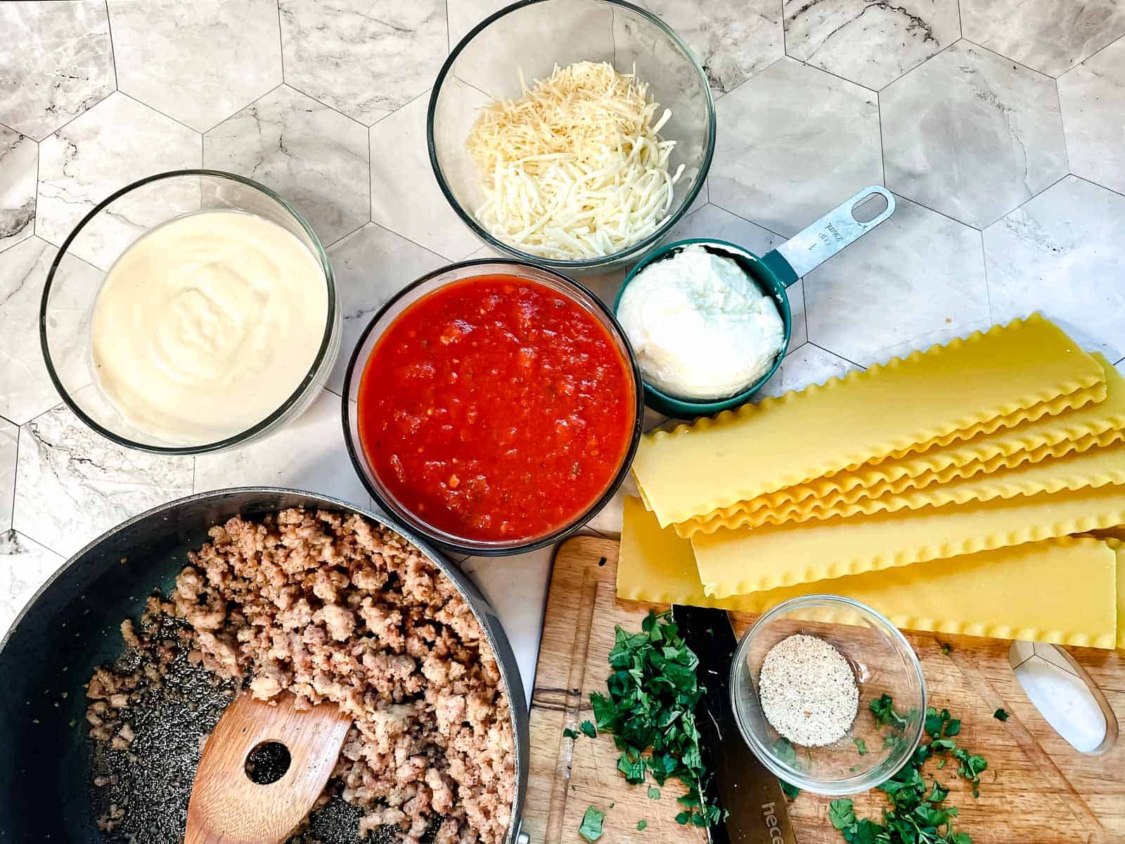 Meat, sauce, cheese and noodles for the dinner.