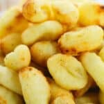 A close-up view of a bowl filled with golden-brown, toasted Air Fryer Gnocchi pieces.