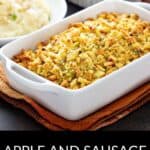A white casserole dish filled with savory Apple and Sausage Dressing sits on a table next to a bowl of fluffy mashed potatoes.