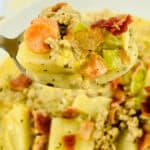 A spoon is holding a serving of soup.