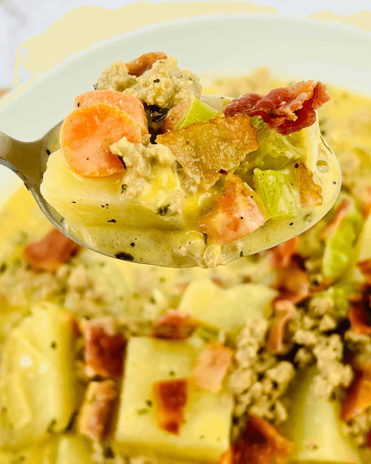 A spoon is holding a serving of soup.