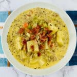A bowl of soup with potatoes and bacon, also known as Bacon cheeseburger Potato Soup.