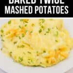 A serving of creamy Baked Twice Mashed Potatoes garnished with chopped chives sits on a white plate.