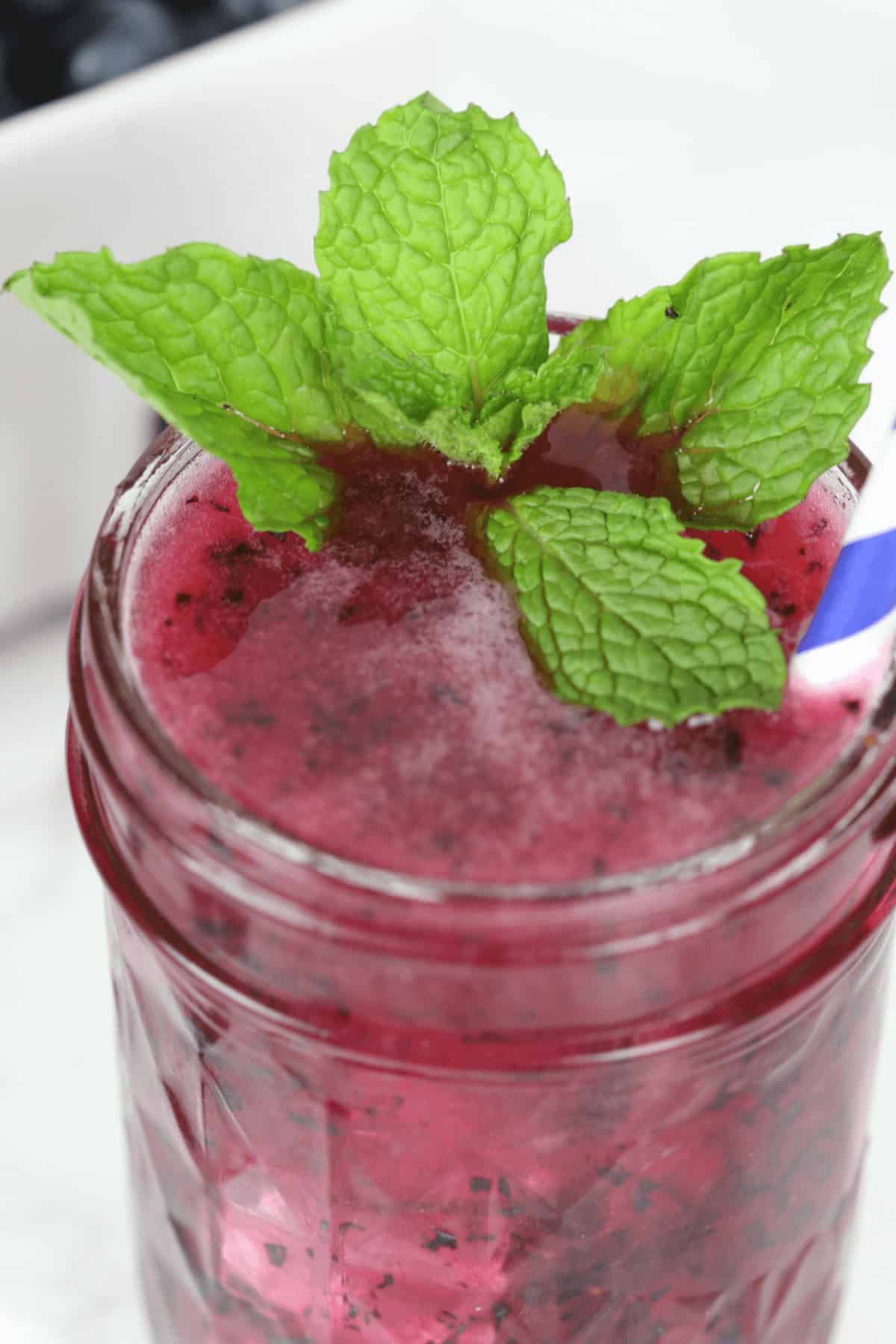 A mason jar of blueberry moonshine.