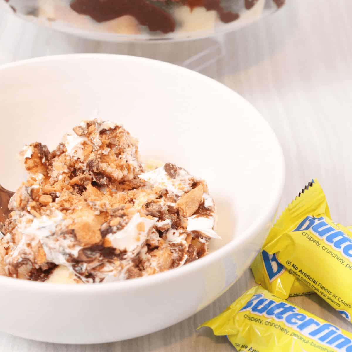 A white bowl of the butterfinger dessert trifle.