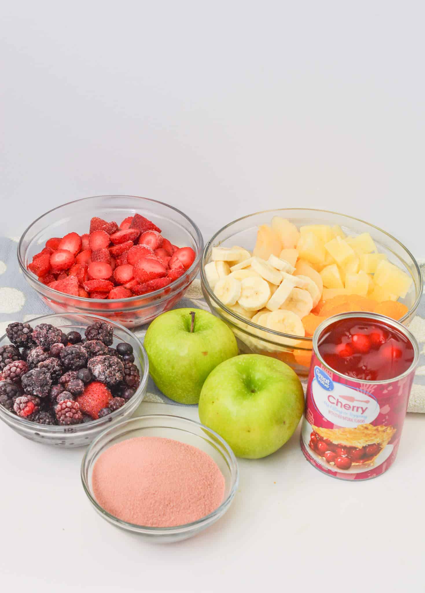 A group of fruit, a can of the pie filling and the gelatin.