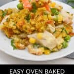 A delightful plate of chicken and stuffing casserole with vibrant corn, peas, and carrots arranged on a pristine white plate, all topped with fresh herbs for that perfect touch.