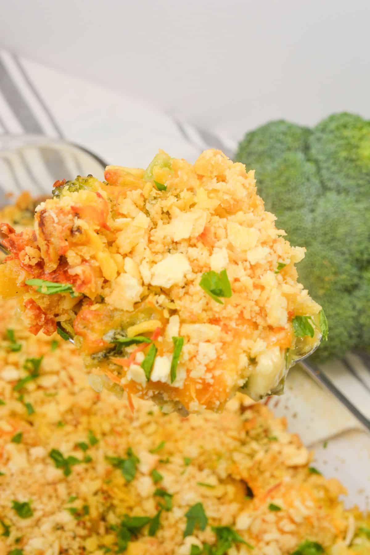 A close-up of a casserole topped with a golden cracker crumb crust, with a head of broccoli in the background.