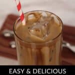 A glass of caramel iced coffee with chocolate swirls, topped with a striped straw, sits enticingly on a wooden surface.