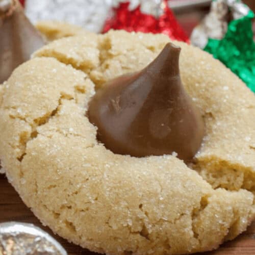 A chocolate kiss cookie surrounded by kiss candies.