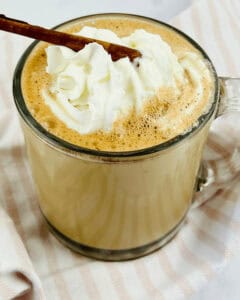 A cinnamon chocolate latte with cream and a sprinkle of cinnamon on top.