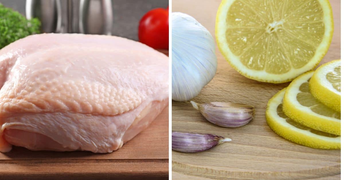 Raw chicken breast on a wooden board beside whole garlic, garlic cloves, and sliced lemon—perfect fresh ingredients to inspire your next slow roasted turkey breast recipe.
