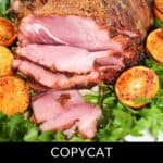 Copycat honey-baked ham, perfectly sliced and surrounded by grilled orange slices and parsley, boasts a crispy brown crust.