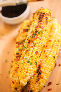 Corn on the cob bathed in asian seasoning.