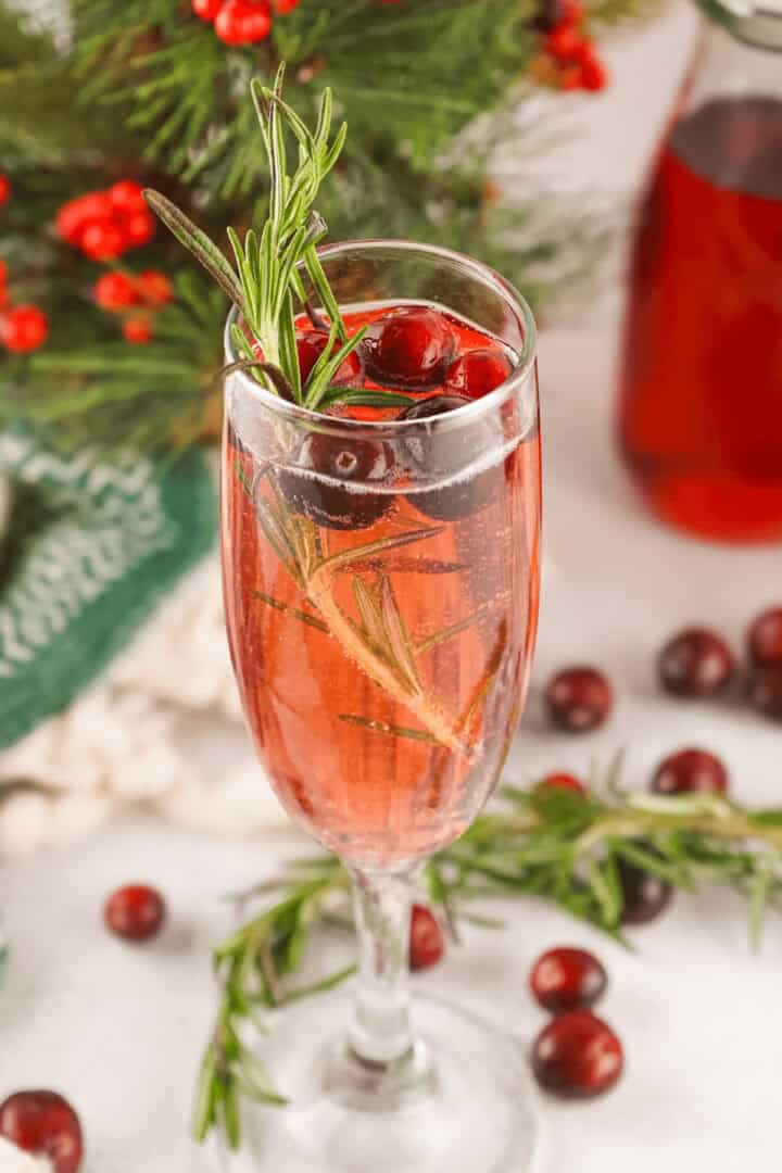 A closeup on the cranberry mimosa decorated with berries.