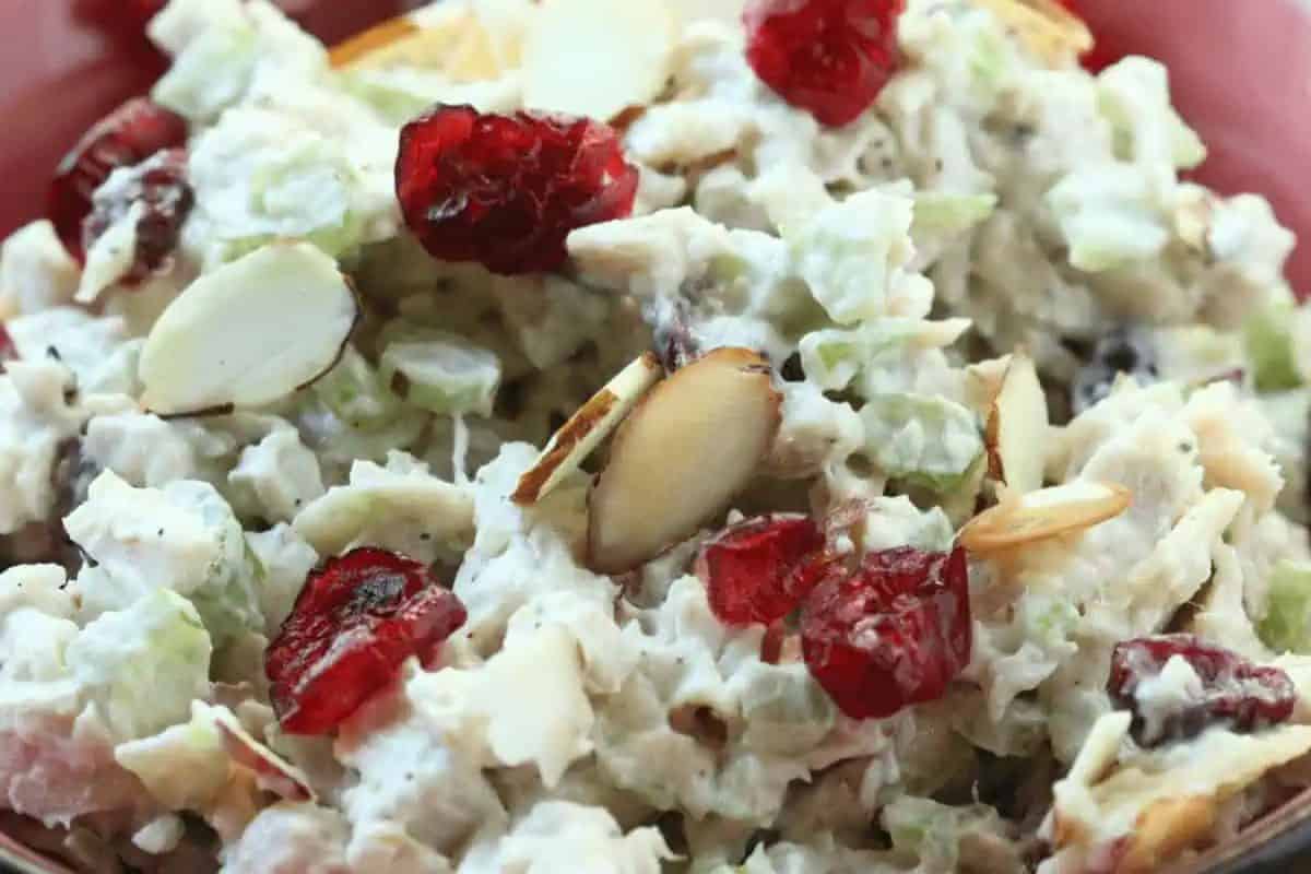 Close-up of a bowl of cranberry turkey salad, with slivered almonds on top.