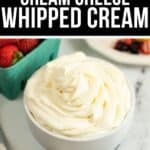 A bowl of fluffy Cream Cheese Whipped Cream sits on a table next to a carton of strawberries and a plate of mixed berries, ready for dipping or topping your favorite desserts.