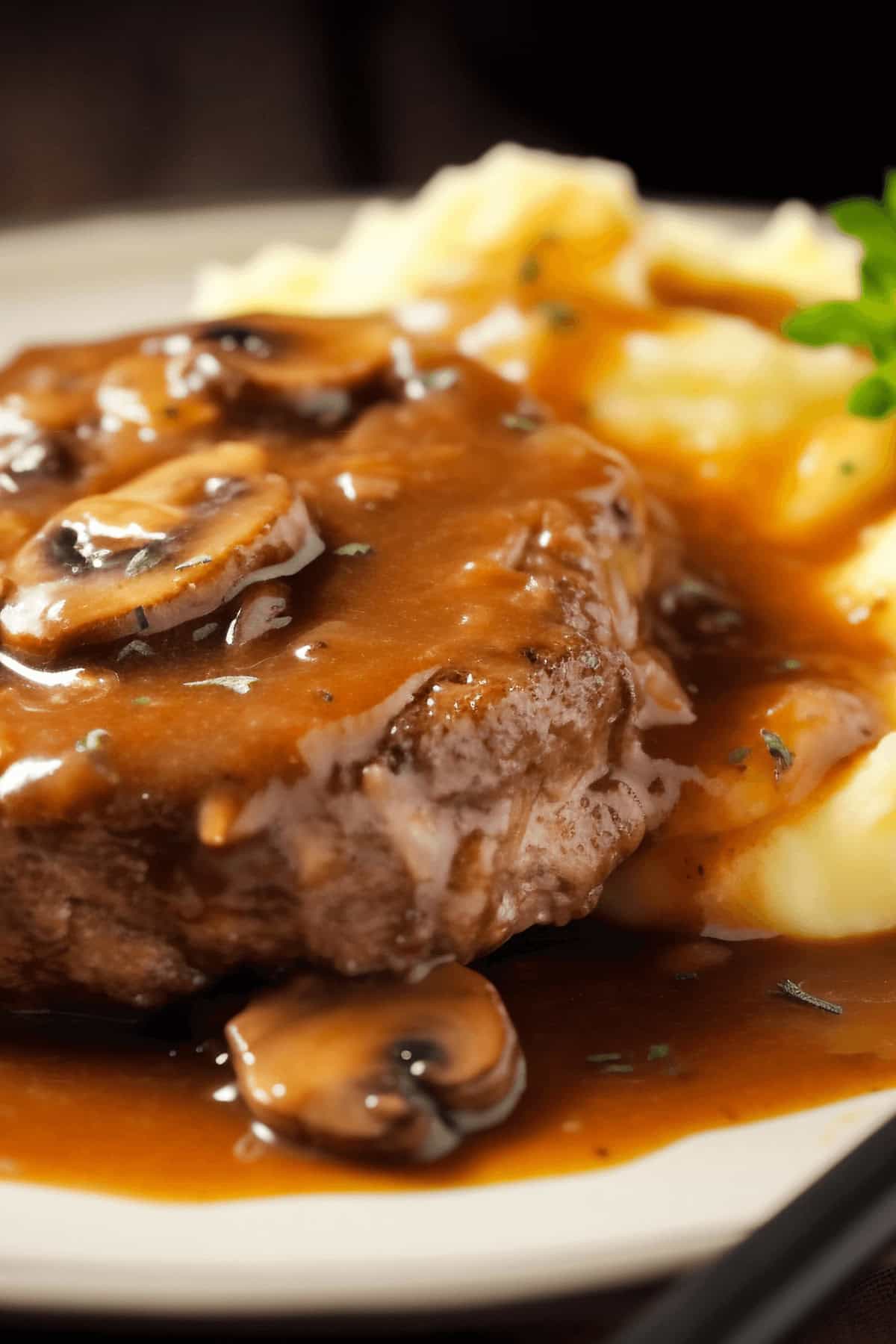 A plate of crock pot salisbury steak with mashed potaotes.