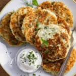 A stack of the cakes with a side of sour cream for the cake.