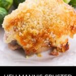 A serving of Hellmann's Crusted Parmesan Chicken with a golden topping is presented on a white plate, accompanied by savory Brussels sprouts.