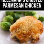 A serving of Hellmann's Crusted Parmesan Chicken with a golden breadcrumb topping, plated alongside Brussels sprouts on a white dish.