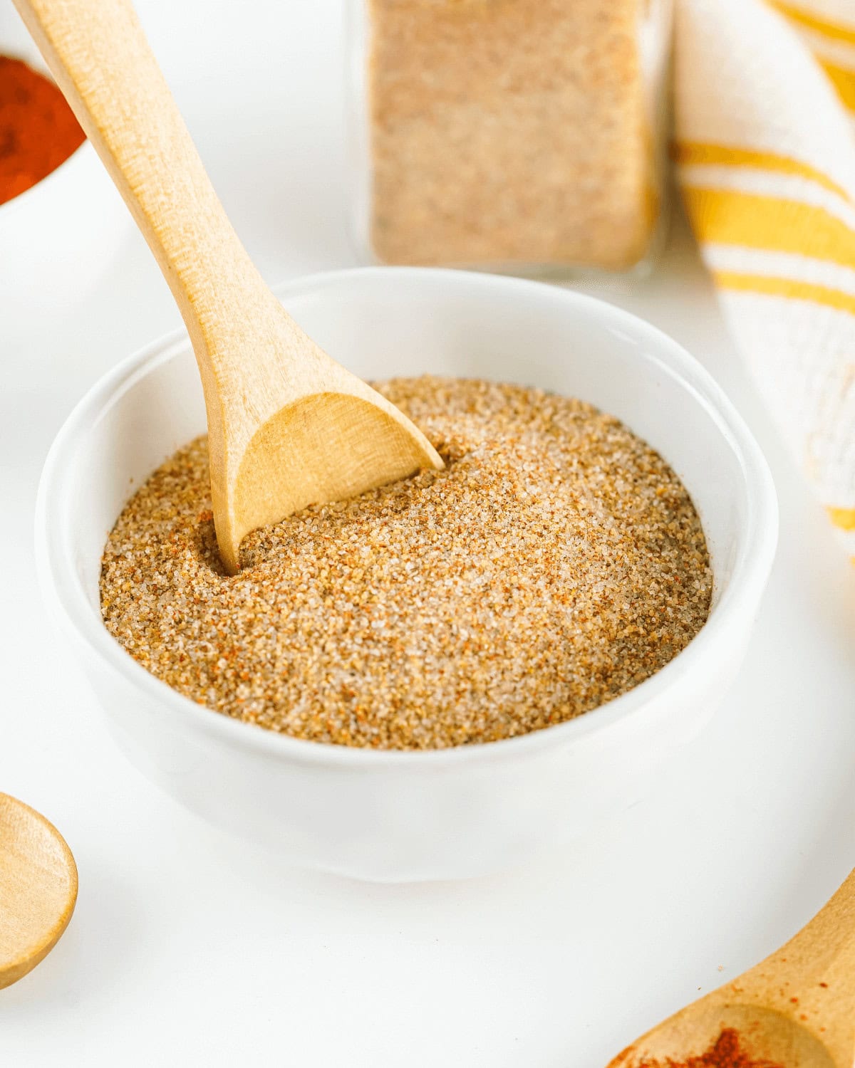 A white bowl with homemade seasoned salt, cinnamon, and nutmeg.