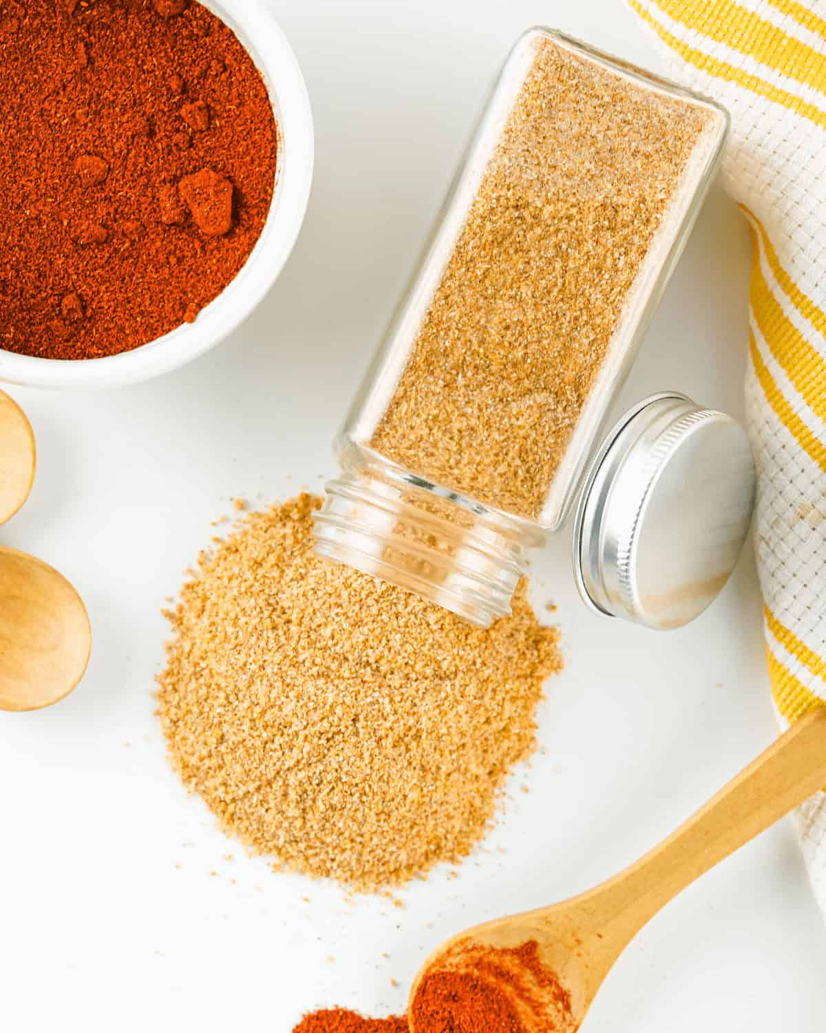Homemade seasoned salt and other spices on a white table.
