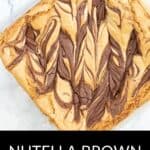 A close-up of Brown Butter Blondies with a marbled Nutella swirl pattern on top, placed on a white surface.