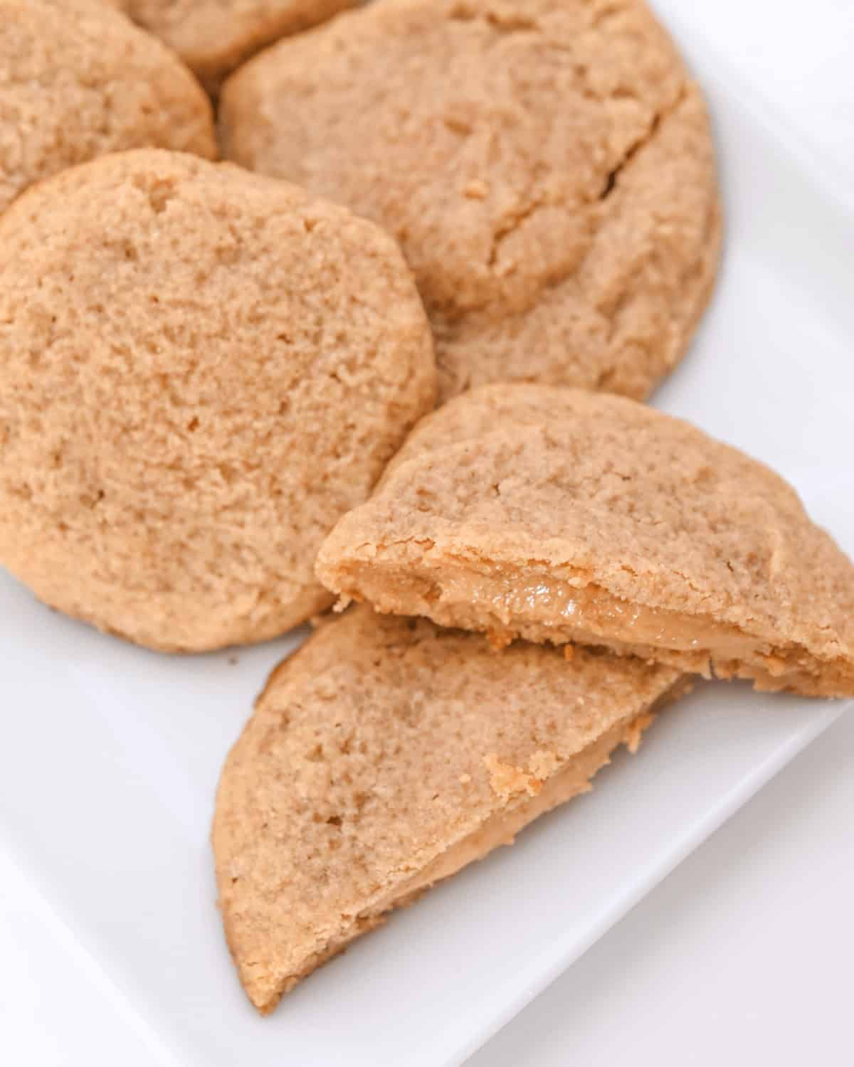 Peanut butter stuffed cookies on a white plate.