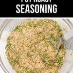 A bowl of mixed pot roast seasoning with dried herbs and spices, featuring a spoon resting inside, ready to use for your favorite Pot Roast Seasoning recipe.
