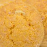 A close-up view of a round, golden-brown Pumpkin Snickerdoodle Cookie with a slightly cracked surface and a light dusting of sugar.