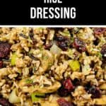 A close-up of a bowl filled with Rice Dressing, featuring wild rice, celery, mushrooms, dried cranberries, and herbs.