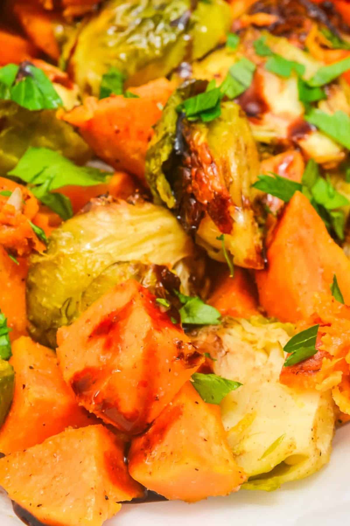 A close-up of roasted Brussels sprouts and sweet potato chunks, garnished with chopped fresh parsley—perfect for anyone who loves roasted vegetables.