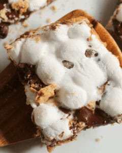 A close-up of Smores Bars with melted chocolate and toasted marshmallows on a graham cracker base.