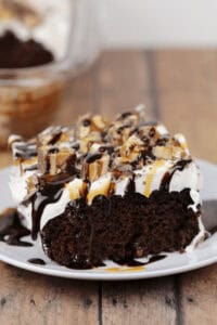 A piece of the snickers cake on a white plate.