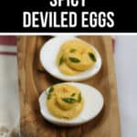 Sriracha spicy deviled eggs served on a wooden platter.