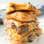 A stack of cheesy Steak Quesadillas wedges filled with tender beef, melted cheese, and fresh herbs on a light surface.