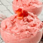 Two glass bowls filled with pink strawberry mousse, reminiscent of a delightful dessert.