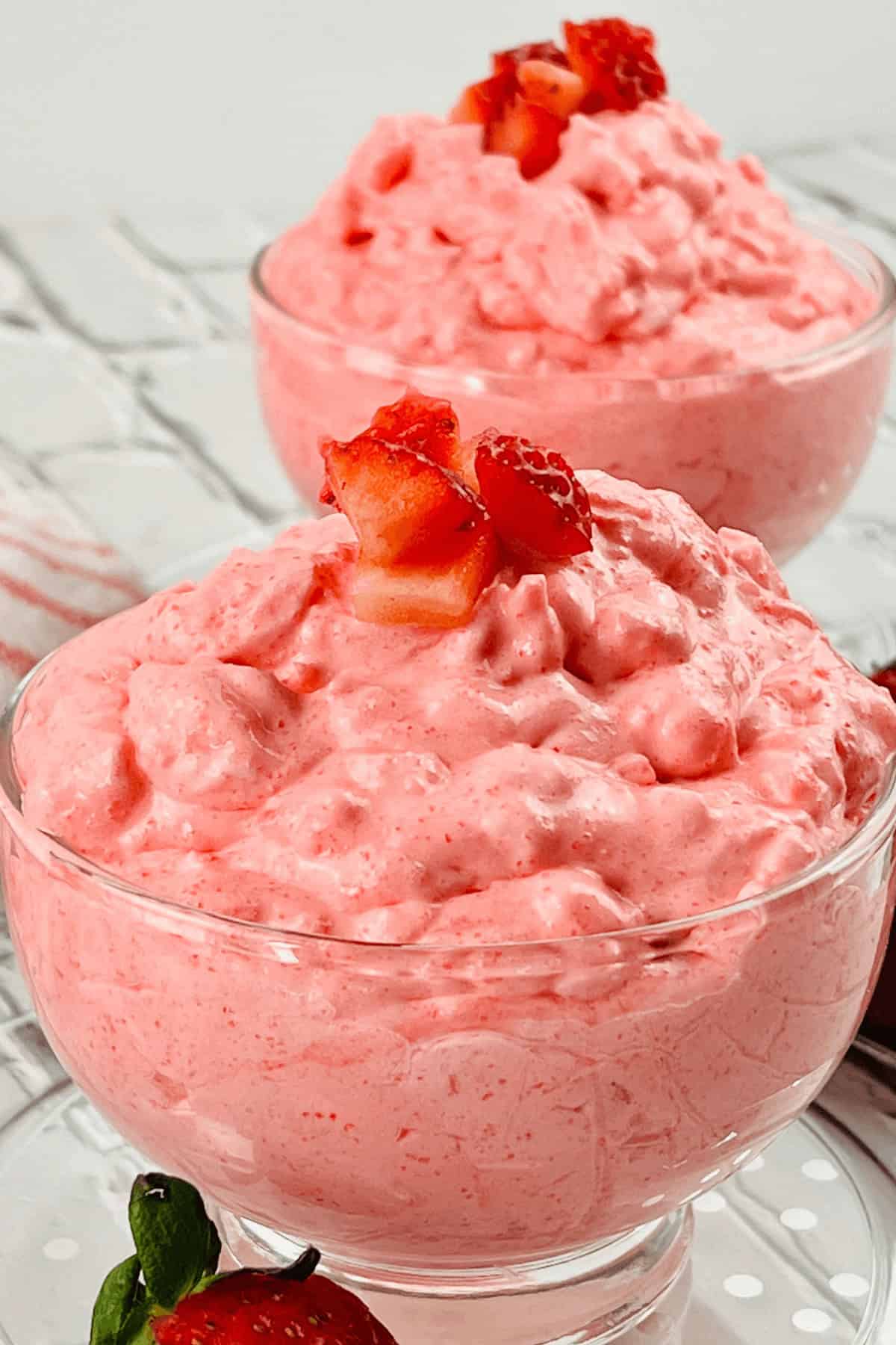 Two glass bowls filled with pink strawberry mousse, reminiscent of a delightful dessert.