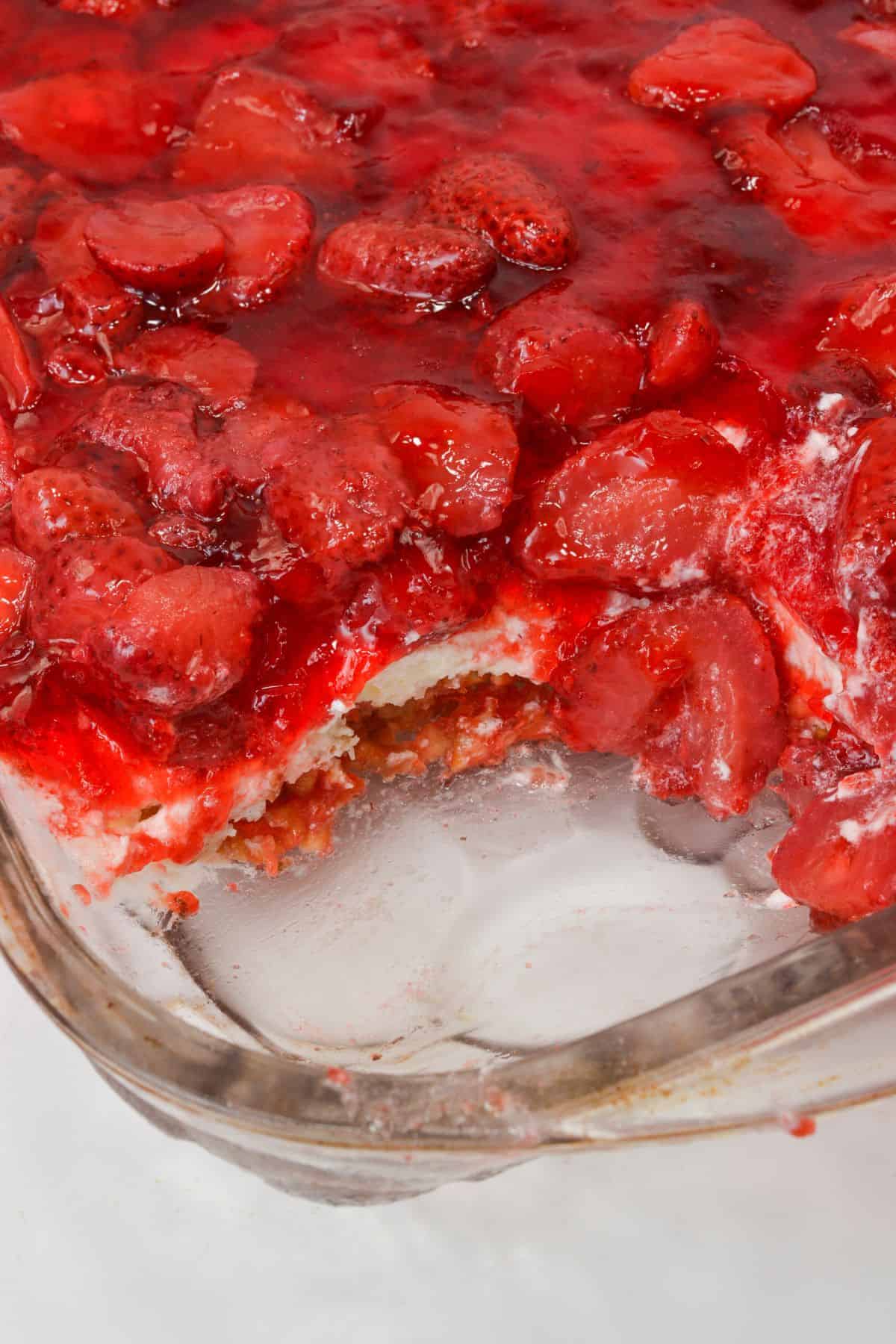 A glass baking dish  with a portion missing, revealing inviting layers.
