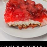 A slice of Pretzel Jello Salad with a crunchy pretzel crust, creamy middle layer, and strawberry jello topping sits on a white plate.