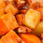 Close-up of Sweet Potato Apple Casserole featuring cubed sweet potatoes, apples, chopped pecans, and a cinnamon-spiced glaze.
