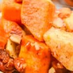 Close-up of a delicious Sweet Potato Apple Casserole, featuring baked sweet potatoes and apples mixed with chopped pecans and cinnamon.