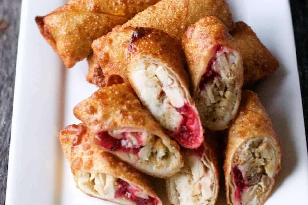 A close-up of some leftover Thaknsgiving egg rolls served on a rectangular white plate.