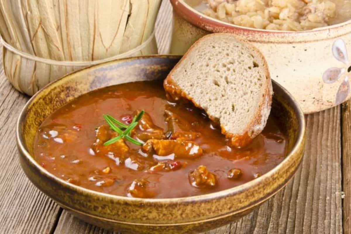 A close-up of a bowl of Thanksgiving leftover goulash served with a piece of bread.