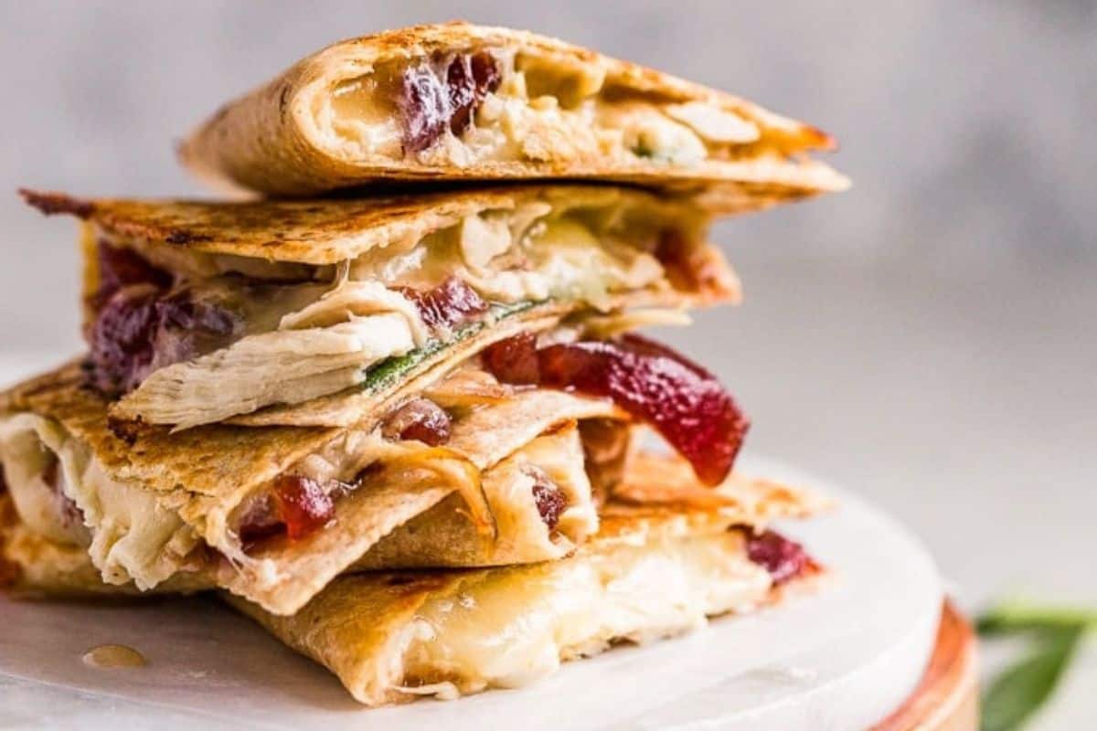 A stack of Thanksgiving quesadillas filled with turkey, cheese, and cranberry sauce.