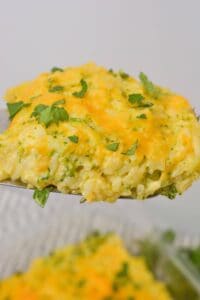 A close-up of a serving of velveeta broccoli rice casserole topped with chopped parsley.