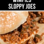 Close-up of a sloppy joe on a wooden surface, featuring ground meat mixed with sauce and diced vegetables between two halves of a bun. Text above reads, "Easy Wimpies (Sloppy Joes).