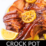 Glazed crock pot spiral ham with citrus garnish.