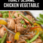 A close-up of Honey Sesame Chicken with vibrant vegetables, like carrots and bell peppers, balanced on a spoon above a sheet pan.